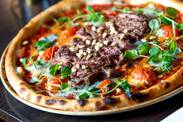 Closeup homemade pizza with grilled beef and pine seeds