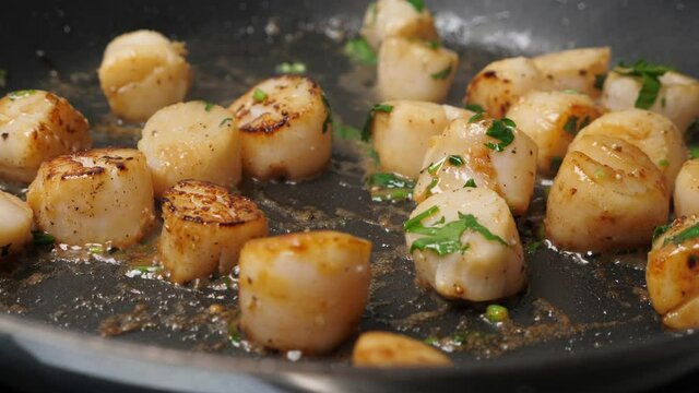 Cook scallops on frying pan. Cooking process. Closeup