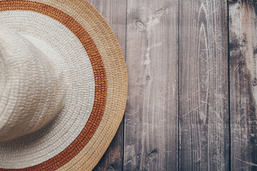 Fototapeta na wymiar straw brown-beige summer hat on wooden background