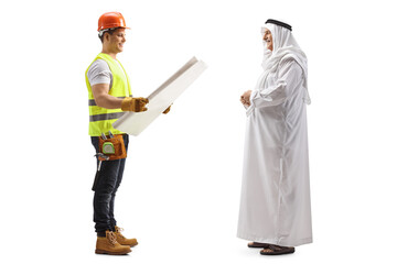 Full length profile shot of a builder holding a blueprint and talking to an arab man