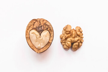 Different forms and areas of walnut. Walnut half in the form of a heart and peeled nut on a white background, isolated