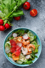 salad with vegetables and shrimp and salmon closeup top view with ingredients on concrete background