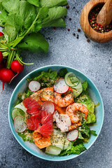salad with vegetables and shrimp and salmon closeup top view with ingredients on concrete background