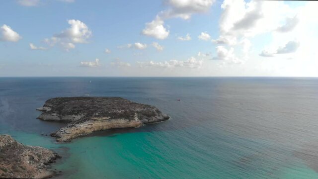 Aerial shot Lampedusa Island (Drone 4k), seagulls, isola dei conigli at sunset - concept of paradise on earth, happiness and travel to beautiful places