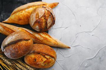 Various types of bread on concrete background with copy space, top view