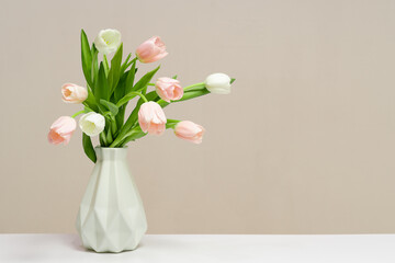 Pink tulips bouquet in white vase on light blue background. Holiday background, copy space. Valentine Day, Mothers day, birthday concept