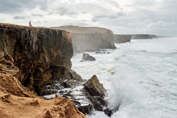 Panorama of cliff Coast Between Monte Clerigo and Amoreira in Portugal at stormy weather.