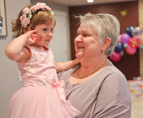 Close up Portrait of Beautiful 2 years Old Toddler Girl in Pink Dress with Her Happy Grandmother, Best Granny, Happy Mothers Day 