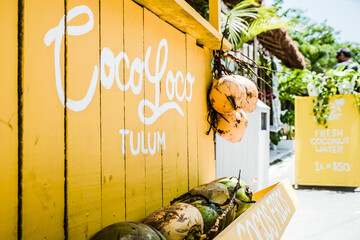 A wooden yellow fresh coconut stand in Tulum Mexico