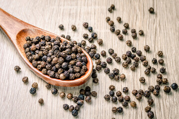 Fototapeta na wymiar Black pepper seed in a wooden spoon, spice used in cooking