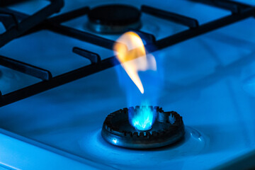 Gas burner with flame from a hole on a gas stove, close-up