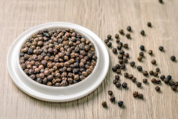 Black pepper seeds in a cup on the table, spices used in cooking