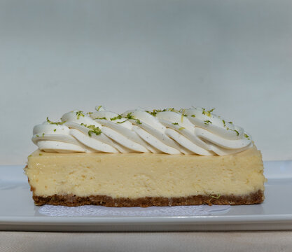 Close Up Of A Key Lime Pie Bar On A White Plate With Piped Whipped Cream 