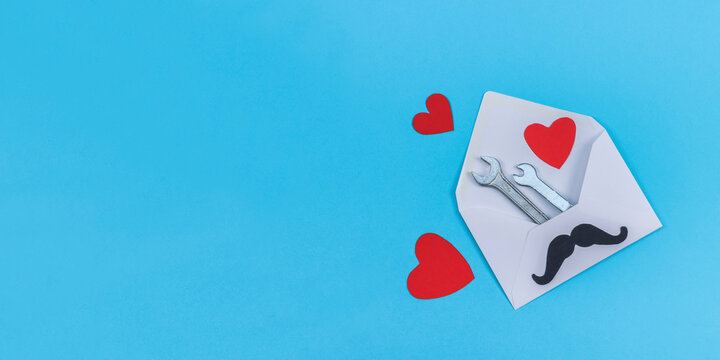 Envelope with wrenches and hearts on blue.
