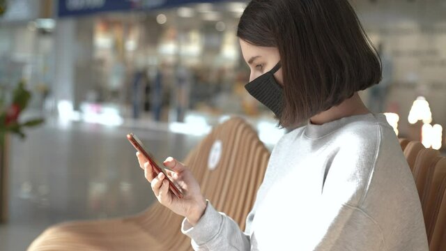 Girl in mask smartphone shopping. a girl in black protective mask in purchases on smartphone shop. Online shopping. Coronavirus quarantine. girl shopper in mask with smartphone coronavirus