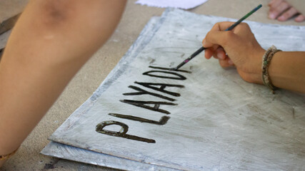 Mano pintando letras con pincel