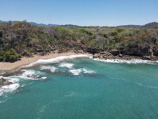 Lush Tropical Beach Paradise with blue water, great waves and rock formations in Montezuma Nicoya Peninsula Costa Rica