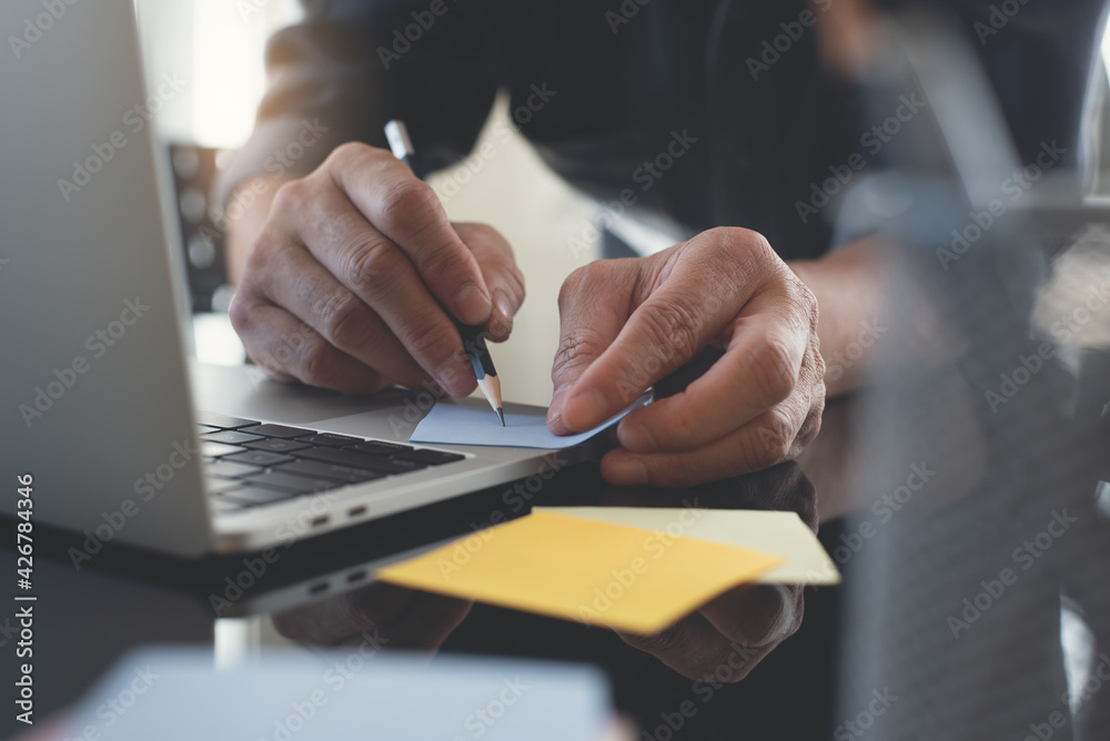 Poster man working on laptop computer searching information and planning startup project in office