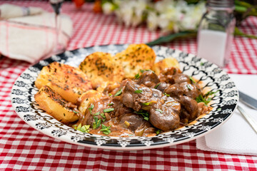 Beef kidney, leek and onion stew with Spanish style potatoes served on a vintage plate.