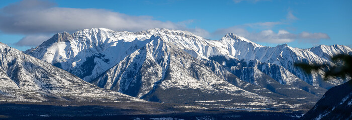 Snowy winter mountain range in Banff National Park in Alberta Canada on sunny day with blue sky.
