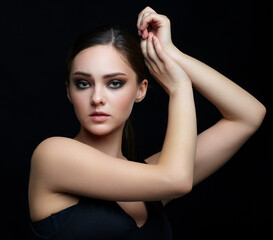 Fototapeta na wymiar Beauty portrait of young woman. Brunette girl with evening female makeup and black dress