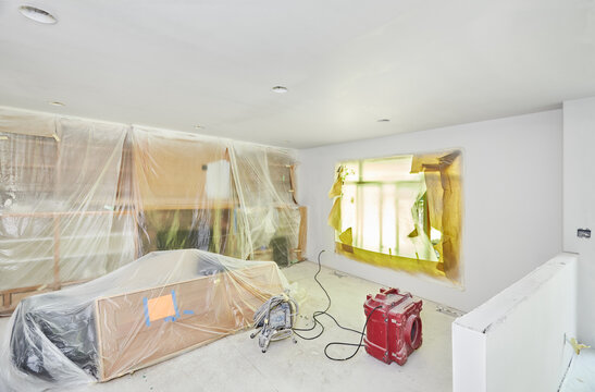 Family room covered in plastic, paper and taped for wall and cailing painting