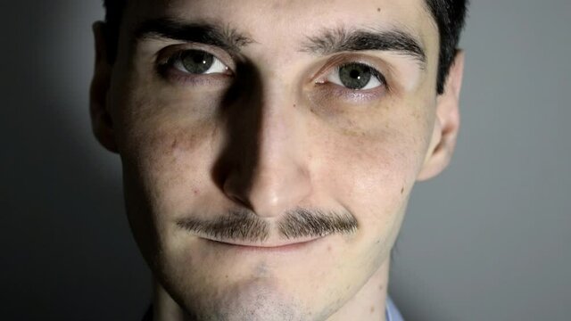 Close up of attractive man face, smiling and raising eyebrow