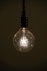 Close up hanging classic Tungsten Lamp in the dark area with rope.