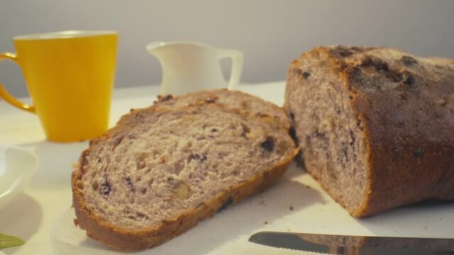 Zoom Out Of Sliced Rye Raisin Bread To The Whole White Dinner Table On Which There Is A Cup Of Tea, Bowl Of Salad, White Milk Jug, Yellow Mug And Some Pack Of Honey On The Front.  Then Camera Zoom In 