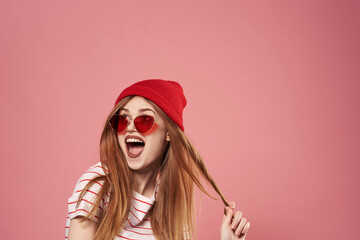 fashionable woman sunglasses and red hat studio pink background fashion