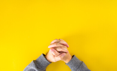 The hands of the man who was clinging to the prayer on the book on the yellow...