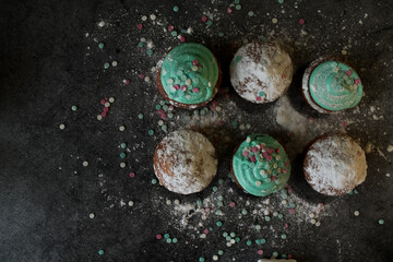 cupcakes in icing and icing sugar
dark table