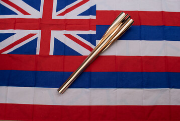 Hawaiian flag with a torch from a large sports event on it.