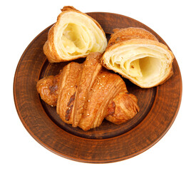 Croissant and cut croissant on a clay plate. Croissant isolated on white background.