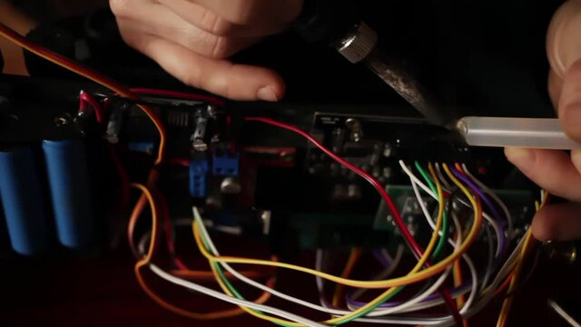 DIY, the machine on electronic control. Home experiments, robotics, smart engineer. Toy for the child. A man fixes a motherboard electronic device. Future technologies. soldering station, batteries