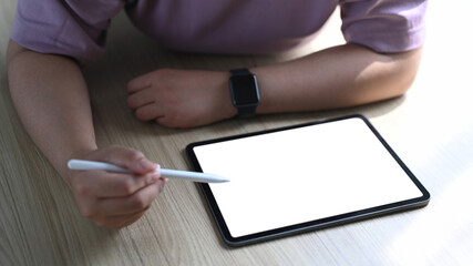 Cropped shot of woman wearing smart wacth holding stylus pen writing on digital tablet.