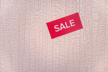 Red sticker with the inscription sale on texture wallpaper for painting on the wall