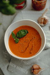 lentil soup with a leaf of basil. cream soup in a white bowl. tomato soup. red cream soup.
