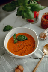 lentil soup with a leaf of basil. cream soup in a white bowl. tomato soup. red cream soup.
