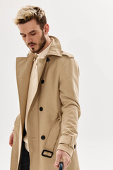 man with trendy hairstyle coat modern style light background
