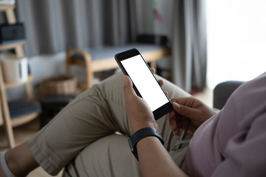 Cropped Shot Of Obese Young Woman Using Smart Phone While Sitting On Confortable Sofa At Home.