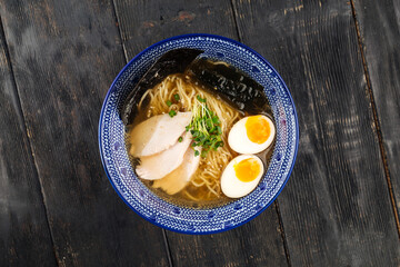 Japanese ramen noodle soup with chicken on the wooden table