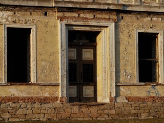 Alte Haustüre / Eingang mit zwei Fenstern in verfallener Hausfassade - Lost Places