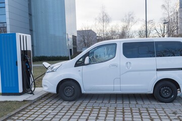 Ein weißer Transporter wird elektrisch betankt