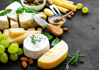 Various types of cheese, grapes, honey and snacks