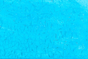 The old cracked paint on a wall surface. Blue background. Peeling paint. Pattern of rustic blue grunge material