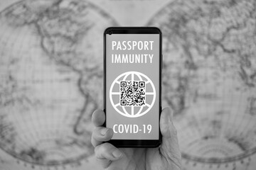 Close-up on caucasian hand holding mobile phone with passport immunity app, for people vaccinated against coronavirus