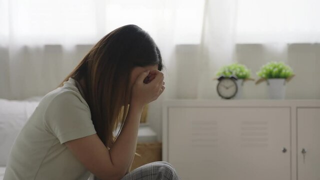 Close up depressed woman sitting on the bed thinking and feeling lonely at home. concept of depression and relationship breakdown