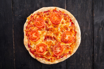 Top view on margherita pizza on the wooden background