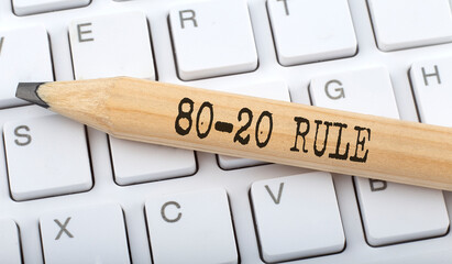 Text 80-20 RULE on wooden pencil on white keyboard. Business concept